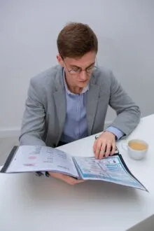Persoană citind un document informativ la o masă