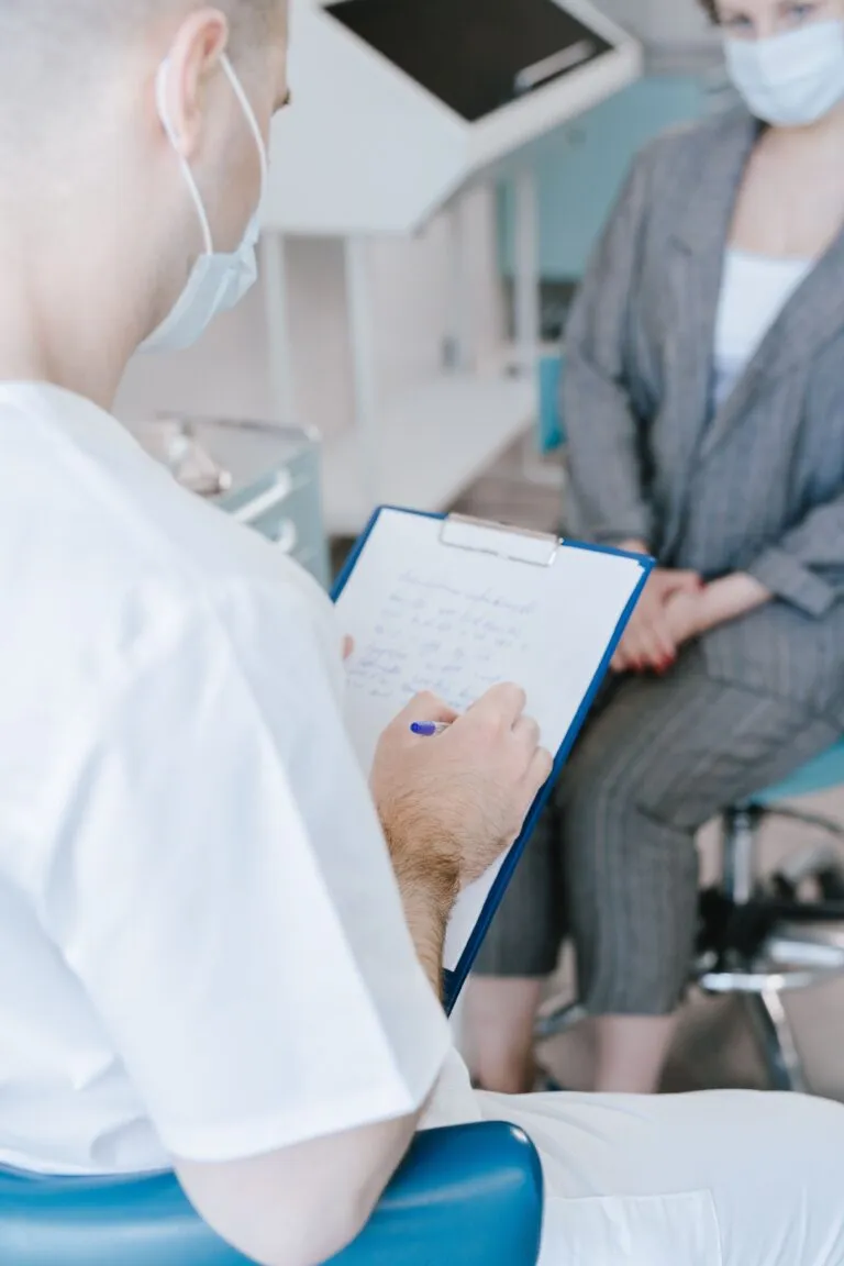 Cadru medical notând informații în timpul unei discuții cu o pacientă