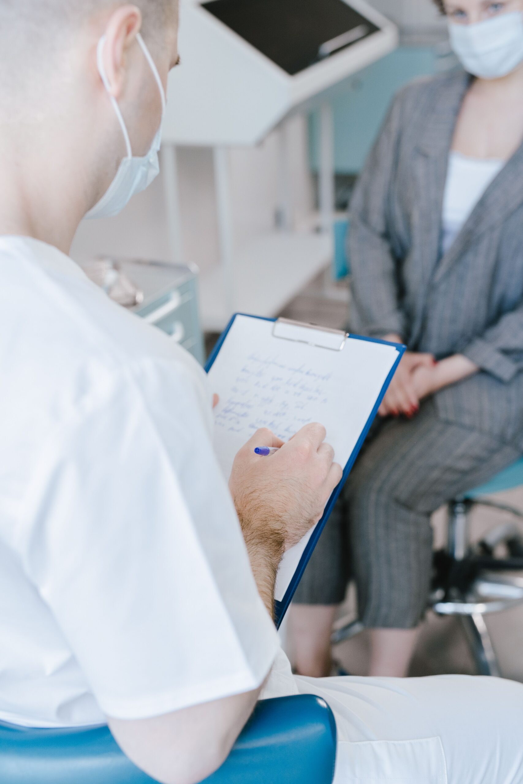 Cadru medical notând informații în timpul unei discuții cu o pacientă