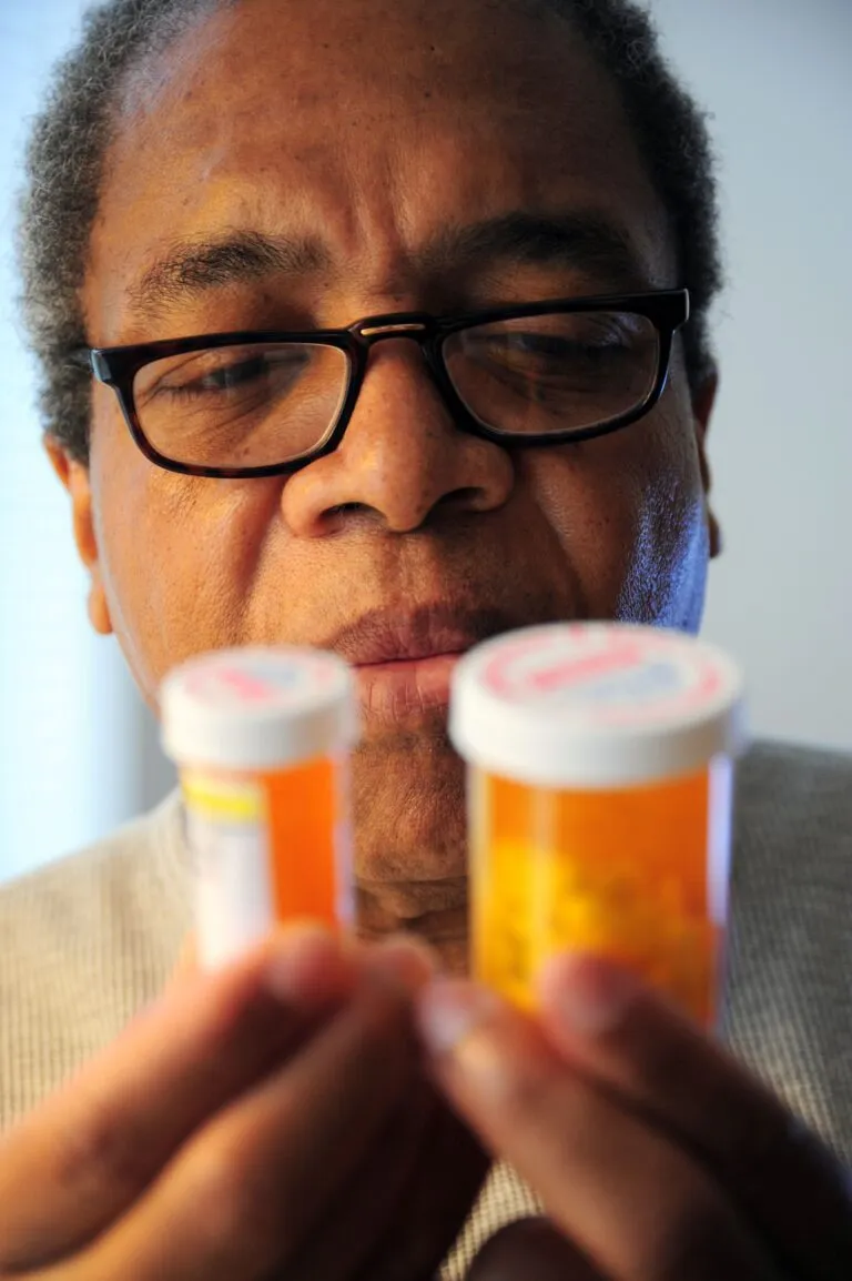 Persoană comparând două flacoane de medicamente